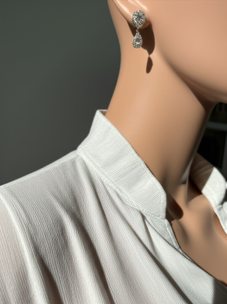 Áo sơ mi trắng và bông tai kim cương.